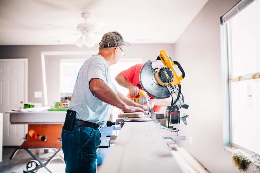 two men cutting wood planks