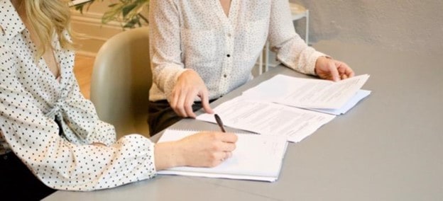 two women working on contracts